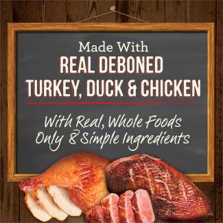 Cooked beef and cooked duck and a chalk board with the words “Made with real deboned turkey, duck &amp; chicken. With real, whole foods. Only 8 simple ingredients.” 
