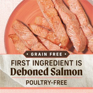 A close-up of strips of cooked salmon presented on a plate. Text below reads "Grain free. First ingredient is deboned salmon. Poultry free"